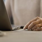 Woman plugging a USB flash drive into her laptop